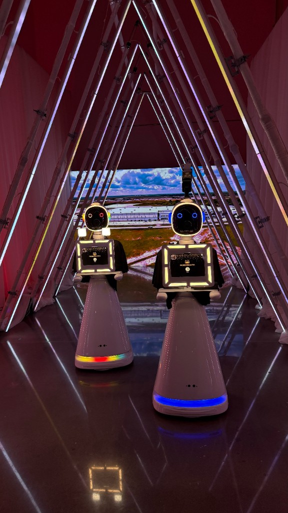 Two Robot Photobooths in an illuminated corporate event tunnel